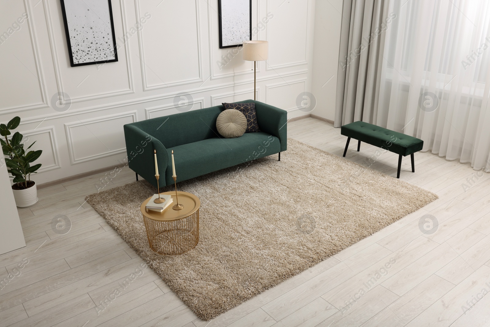 Photo of Stylish living room with soft beige carpet, coffee table and sofa, above view. Interior design