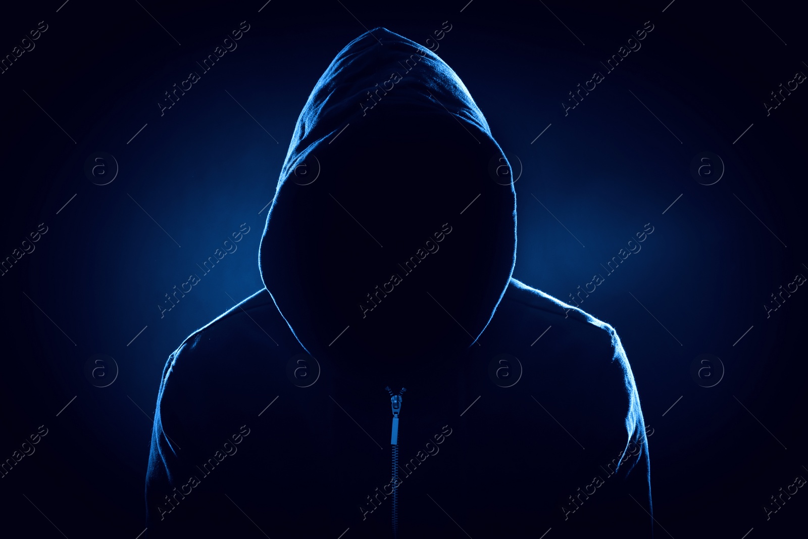 Image of Anonymous man in hood on black background, color toned