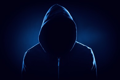 Image of Anonymous man in hood on black background, color toned