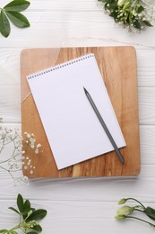 Photo of Guest list. Notebook, pencil, beautiful flowers and ribbon on white wooden background, flat lay