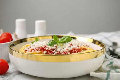 Photo of Delicious pasta with tomato sauce, chicken and parmesan cheese on white marble table, closeup