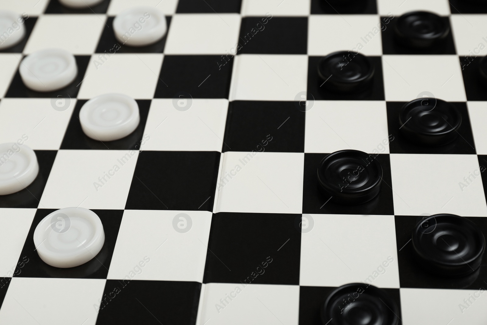 Photo of Checkerboard with game pieces as background, closeup