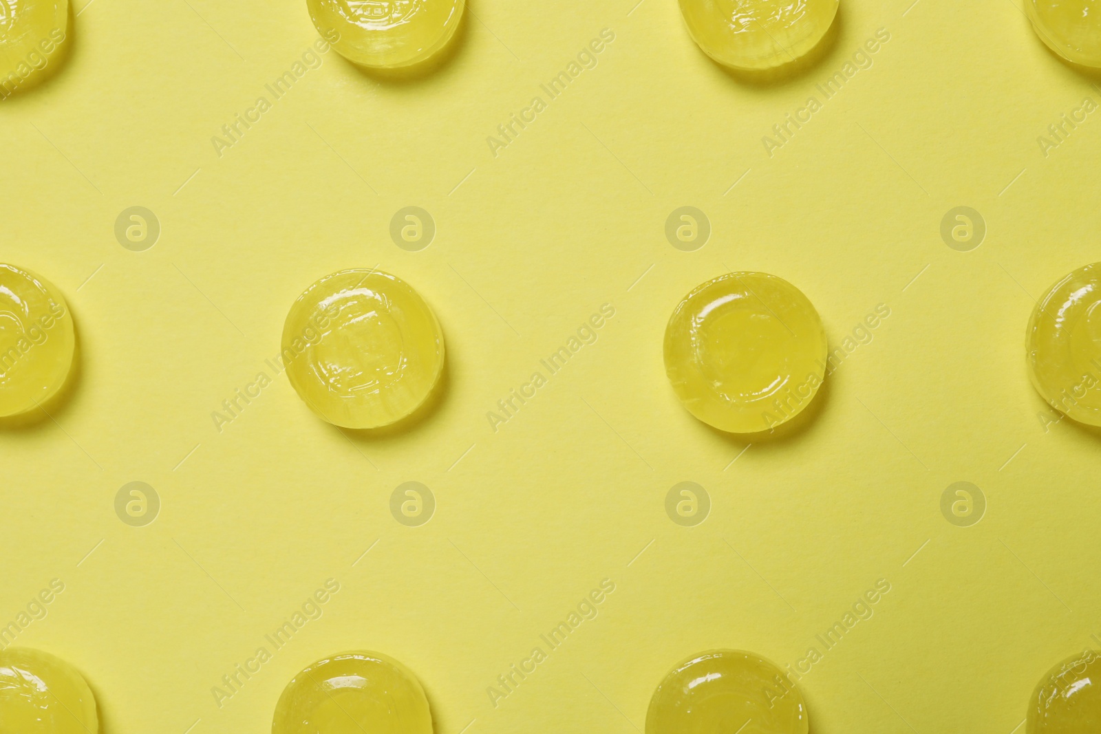 Photo of Sweet candies on yellow background, flat lay