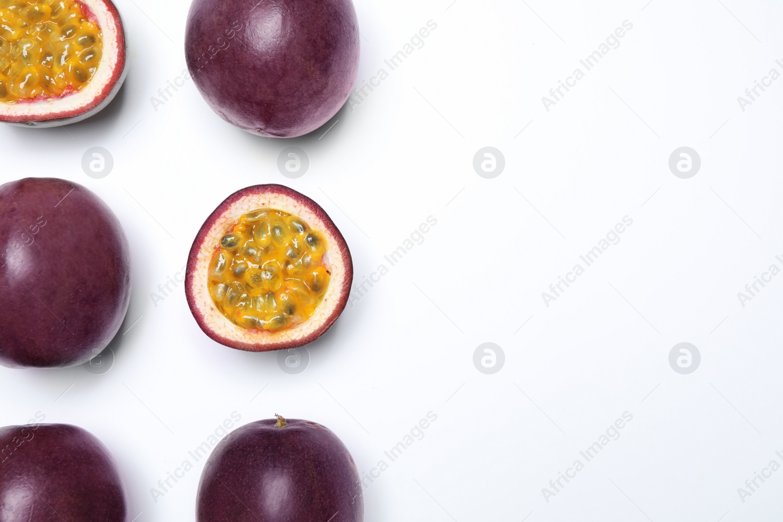 Photo of Fresh ripe passion fruits (maracuyas) on white background, flat lay. Space for text