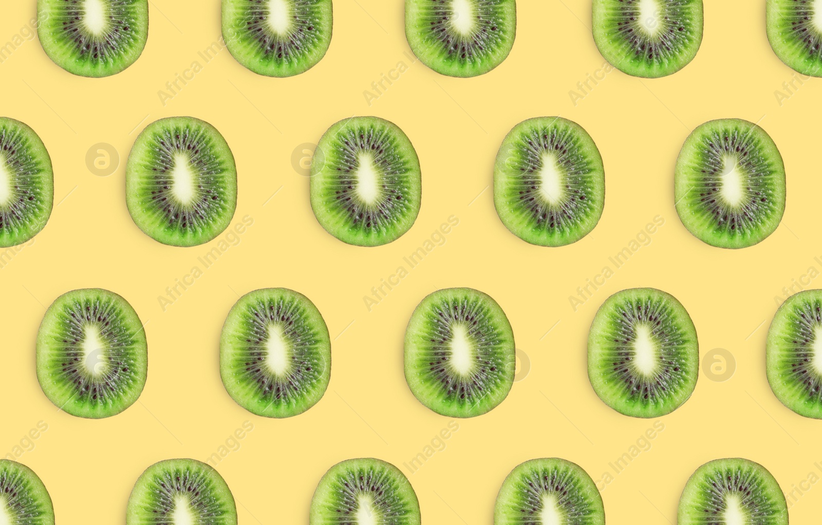 Image of Slices of kiwi fruits on yellow background, flat lay
