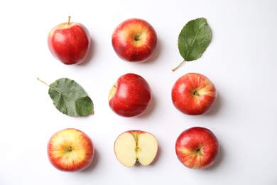 Photo of Fresh ripe red apples and leaves on white background, flat lay