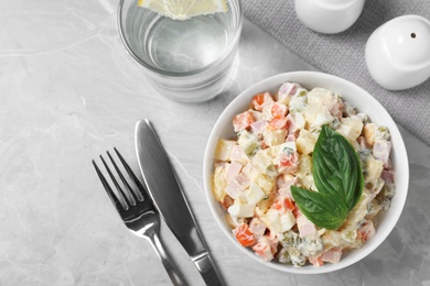 Photo of Delicious salad Olivier on light table, flat lay