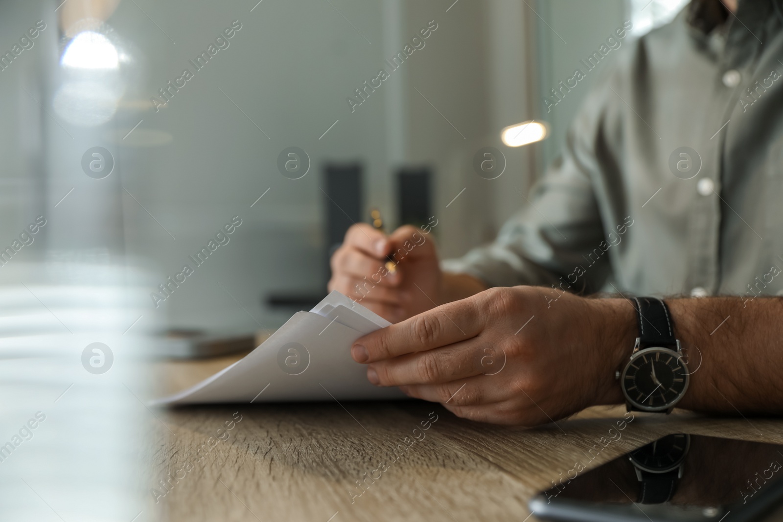 Photo of Businessman working with documents at wooden desk in office, closeup