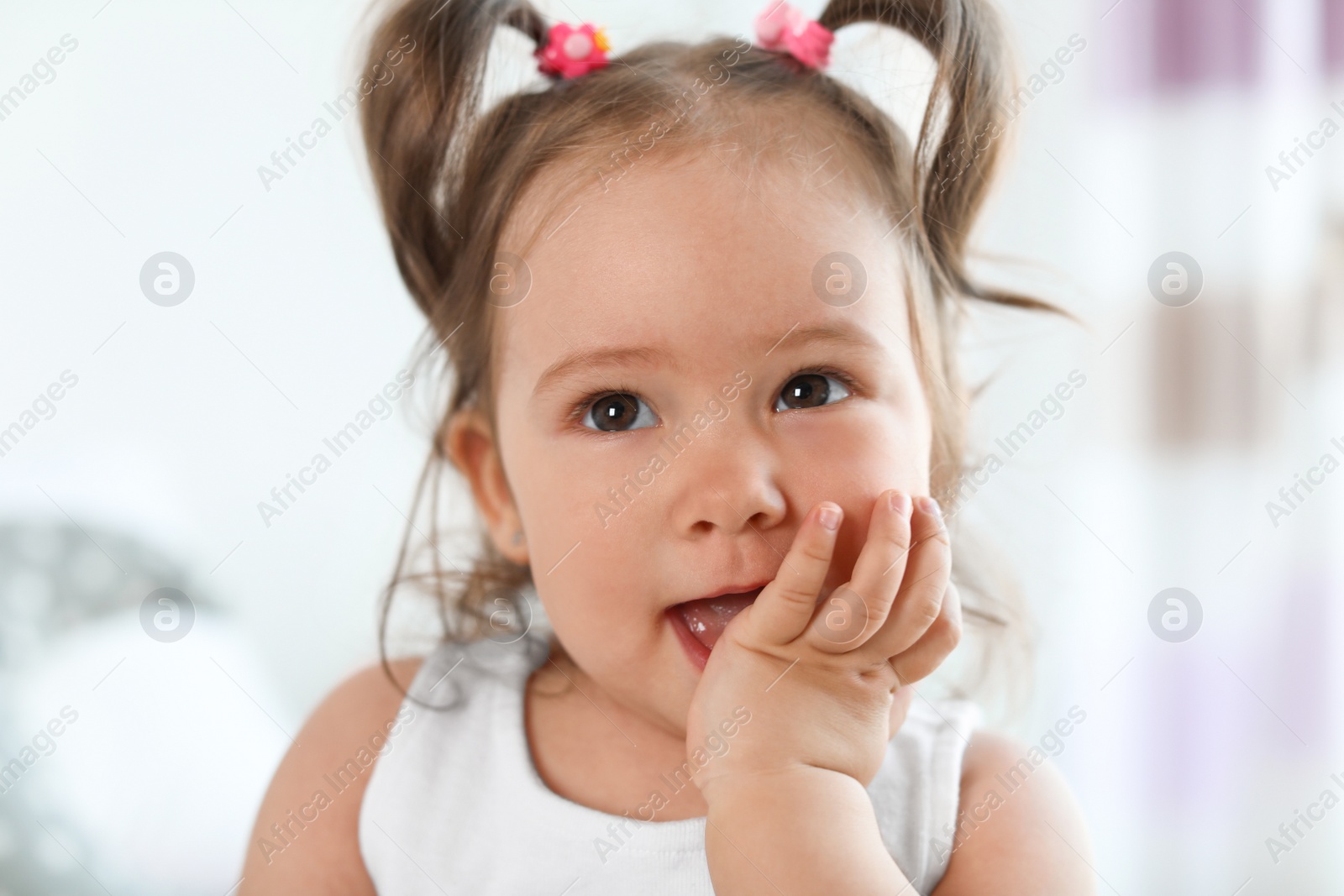 Photo of Adorable little baby girl on blurred background