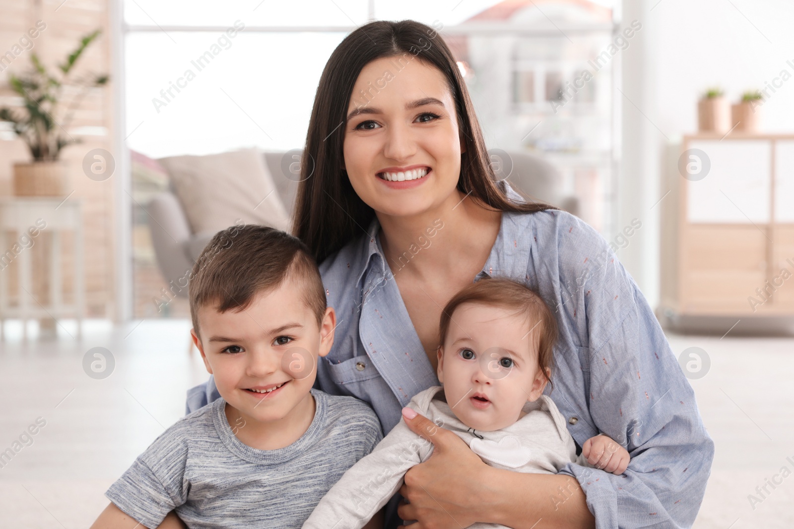 Photo of Happy mother with her cute children at home. Family time