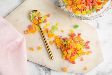 Mix of delicious candied fruits on white marble table, flat lay