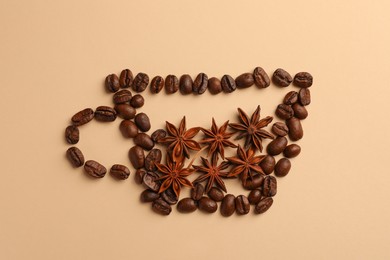 Photo of Cup made with coffee beans and anise stars on beige background, flat lay