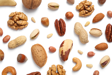 Photo of Different delicious nuts on white background, flat lay