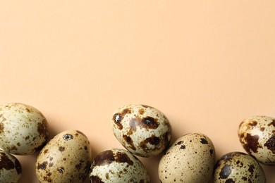 Photo of Many speckled quail eggs on beige background, flat lay. Space for text