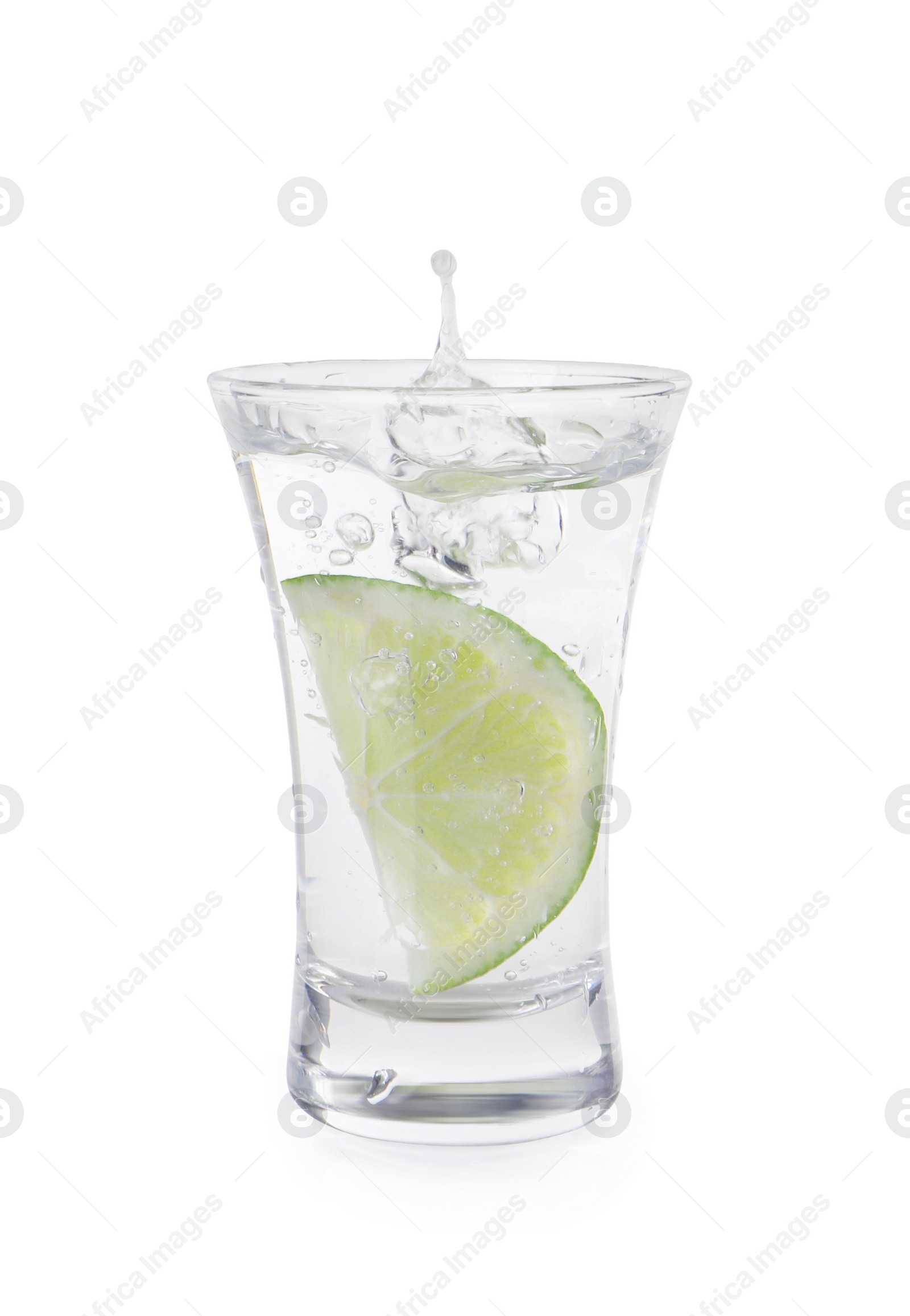 Photo of Vodka splashing out of shot glass with lime on white background