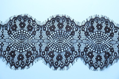 Black lace on light blue background, top view