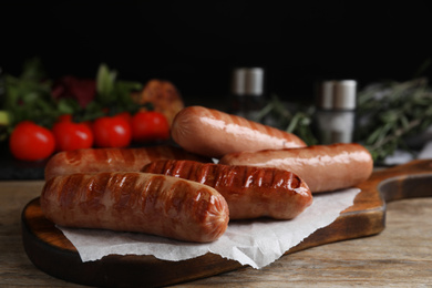 Photo of Delicious grilled sausages served on wooden table