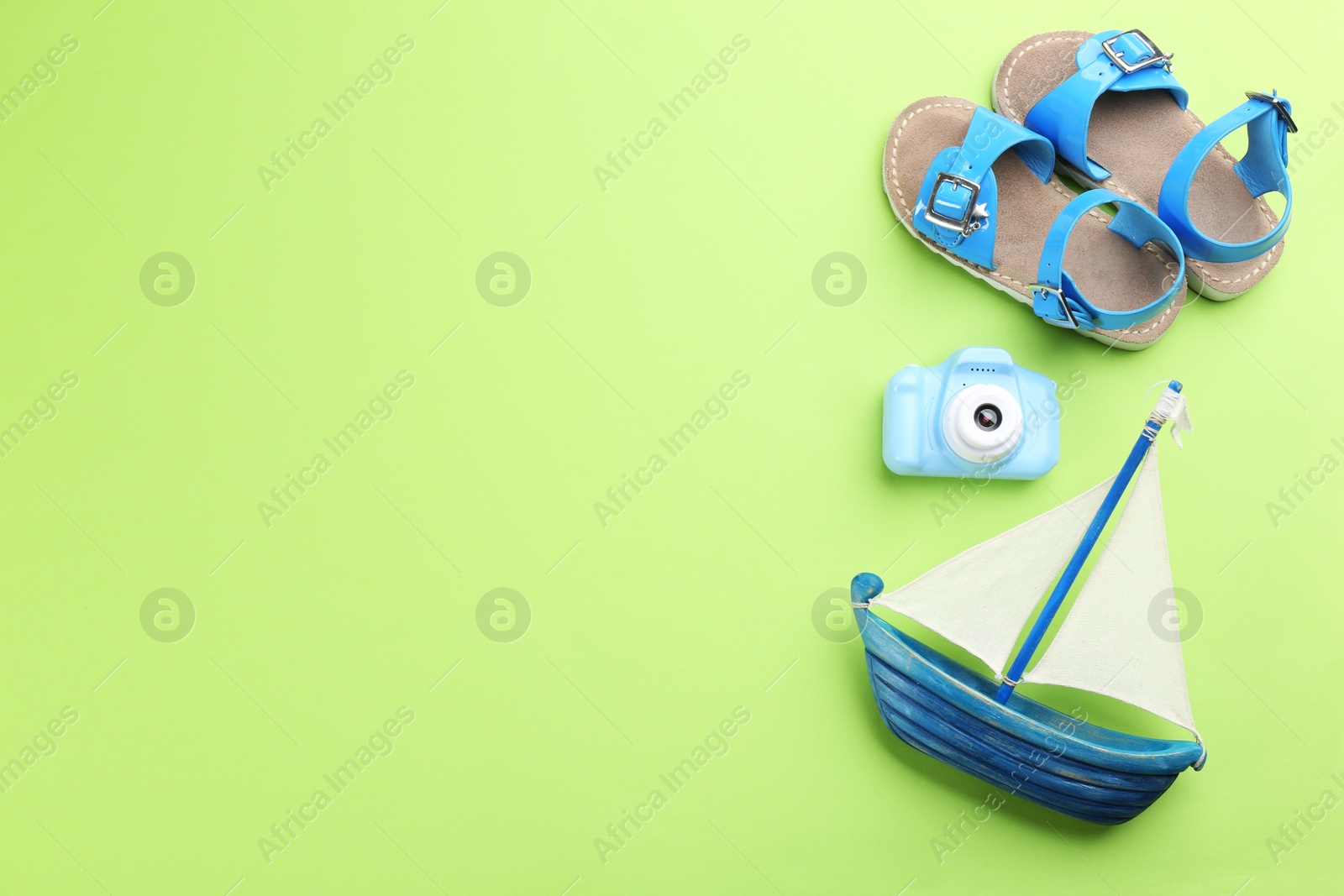 Photo of Flat lay composition with little photographer's toy camera on light green background. Space for text