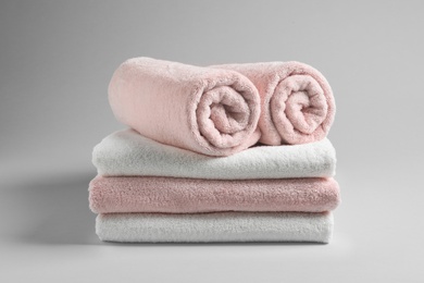 Photo of Stack of fresh towels on light background
