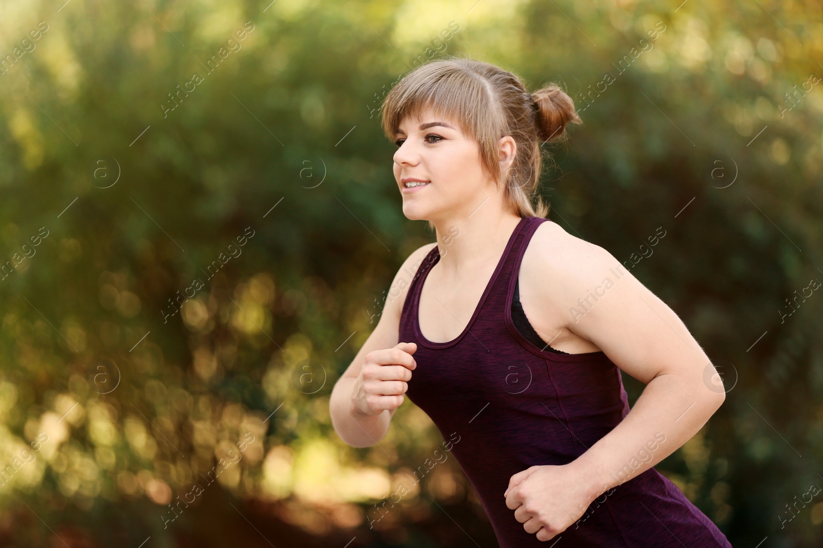 Photo of Young woman running in park on sunny day