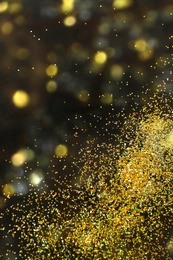 Photo of Shiny golden glitter on blurred background with bokeh effect. Space for text