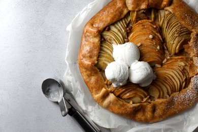 Delicious apple galette served with ice cream on light grey textured table, top view. Space for text