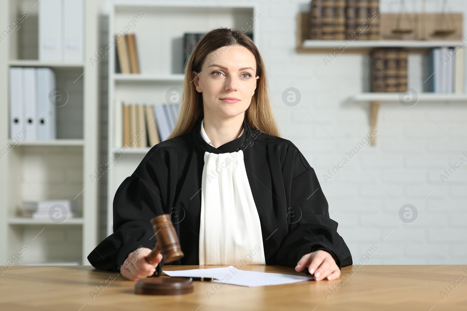 Photo of Judge striking wooden mallet at table indoors