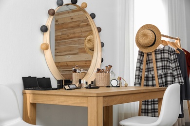 Photo of Cosmetics and brushes on dressing table in makeup room