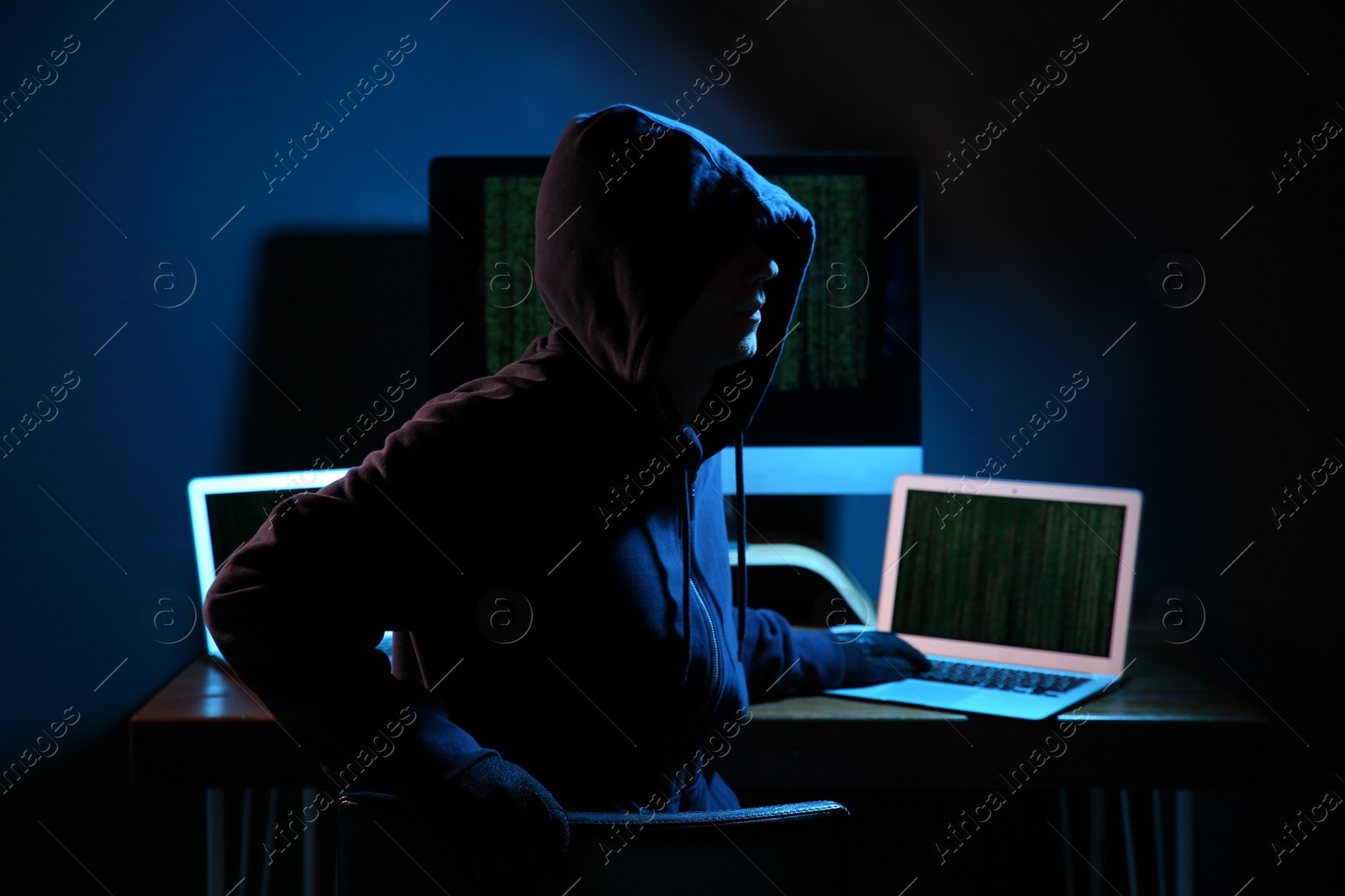 Photo of Hacker with computers in dark room. Cyber crime