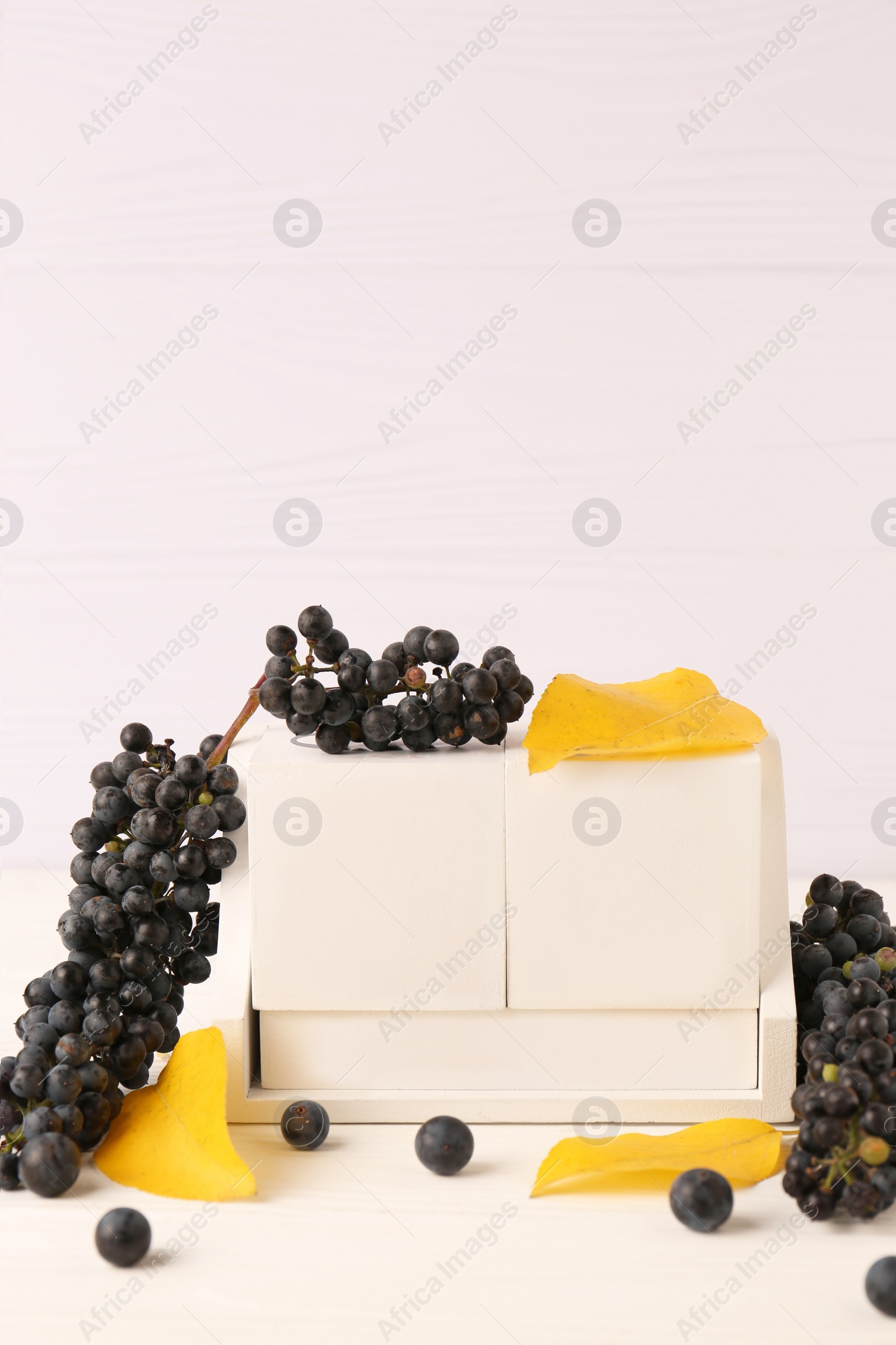 Photo of Thanksgiving day, holiday celebrated every fourth Thursday in November. Block calendar, yellow leaves and berries on white wooden table, space for text