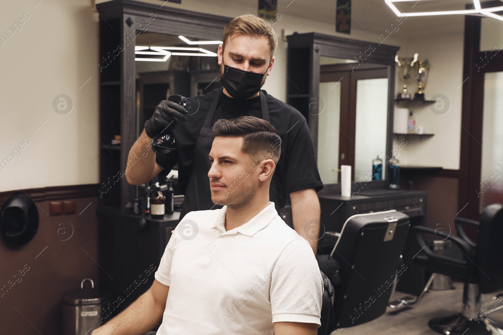 Photo of Professional hairdresser making stylish haircut in salon