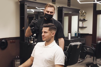 Professional hairdresser making stylish haircut in salon