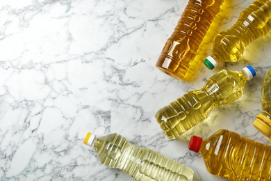 Photo of Bottles of oil and space for text on marble background, top view