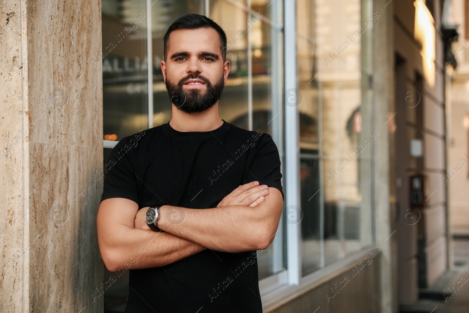 Photo of Portrait of handsome bearded man near building outdoors. Space for text