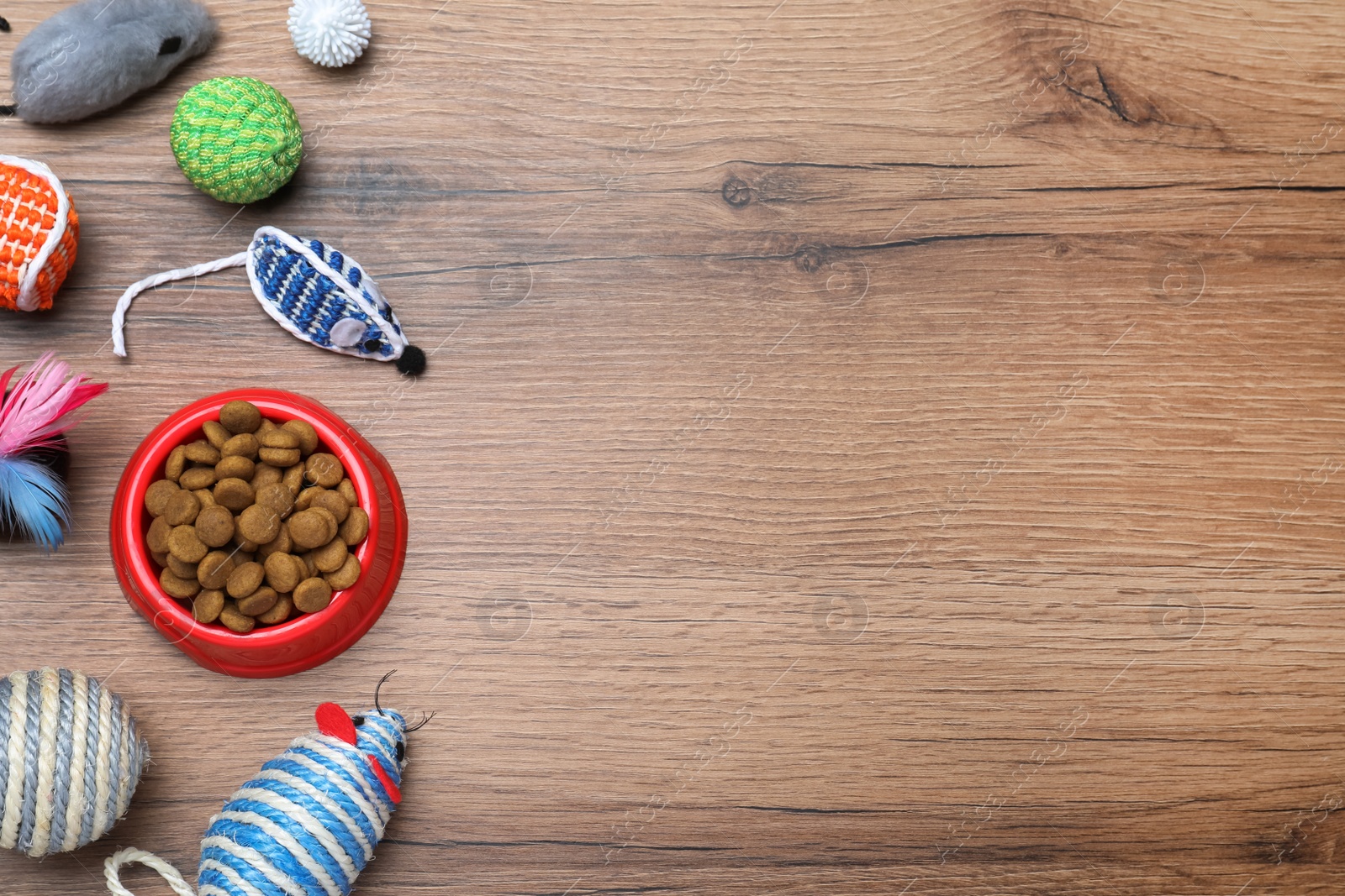Photo of Different pet toys and feeding bowl on wooden background, flat lay. Space for text