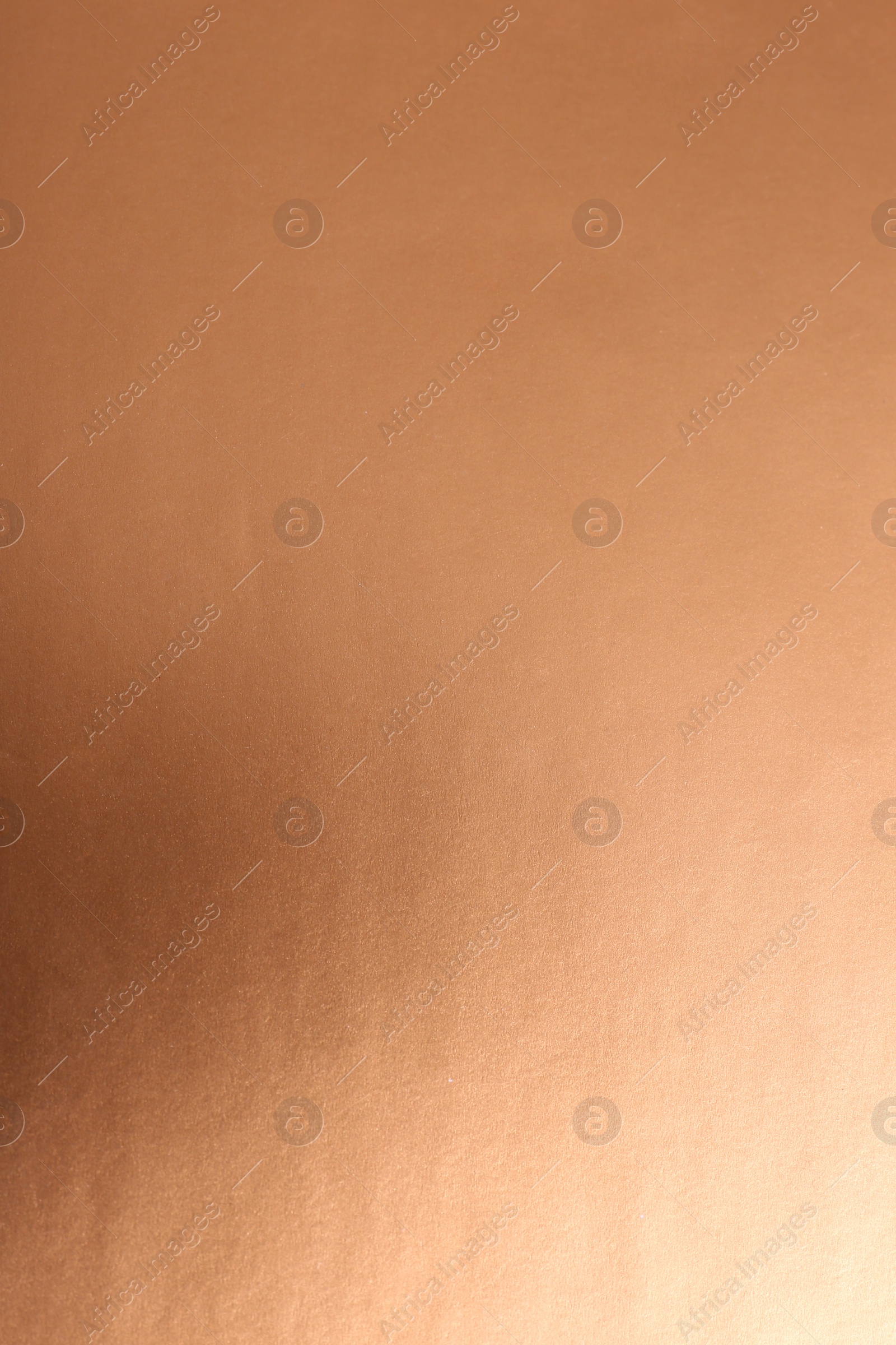 Photo of Plain rose gold surface as background, closeup