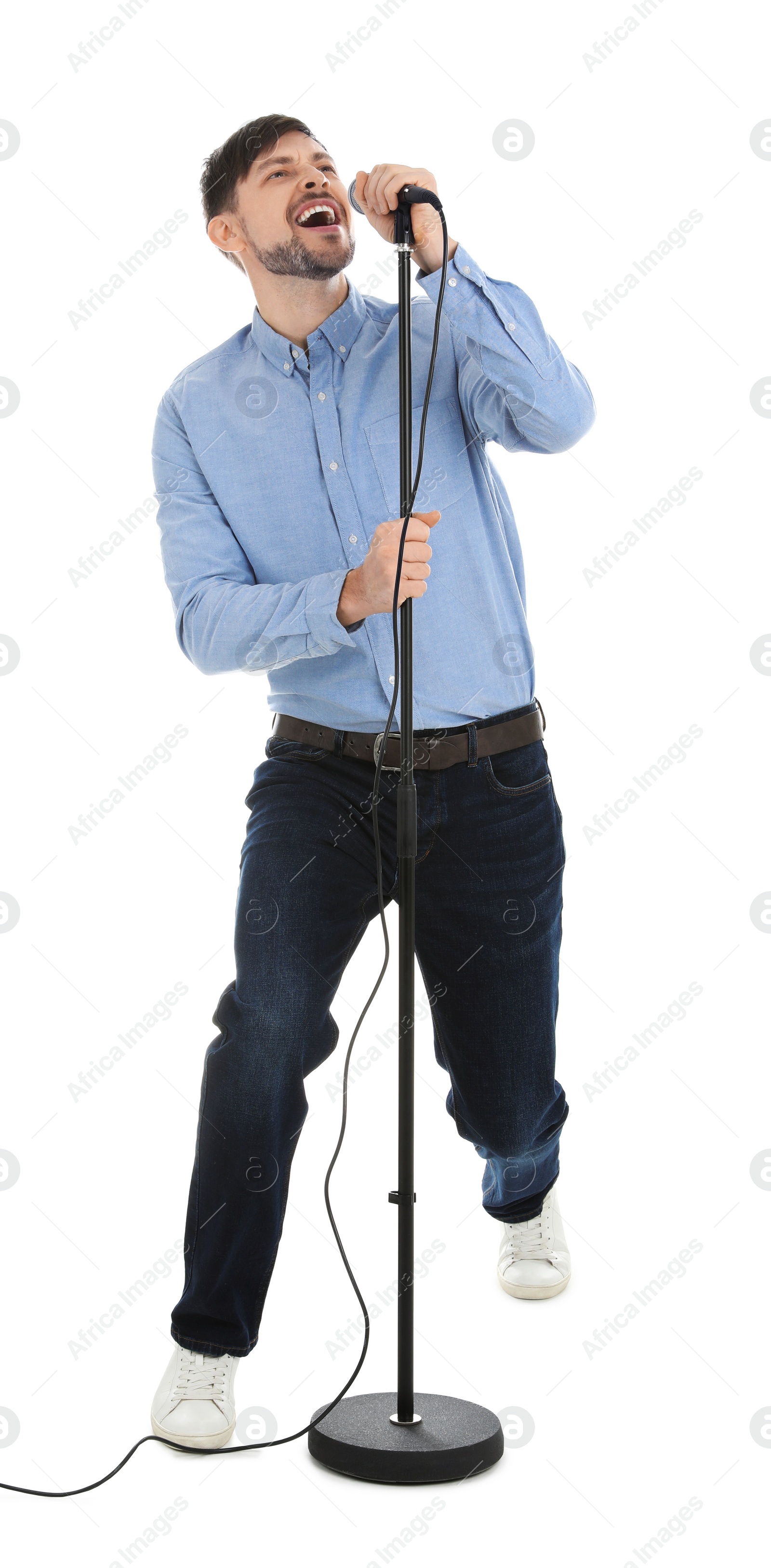 Photo of Handsome man singing in microphone on white background