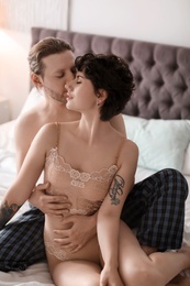 Photo of Lovely young couple being intimate on bed at home