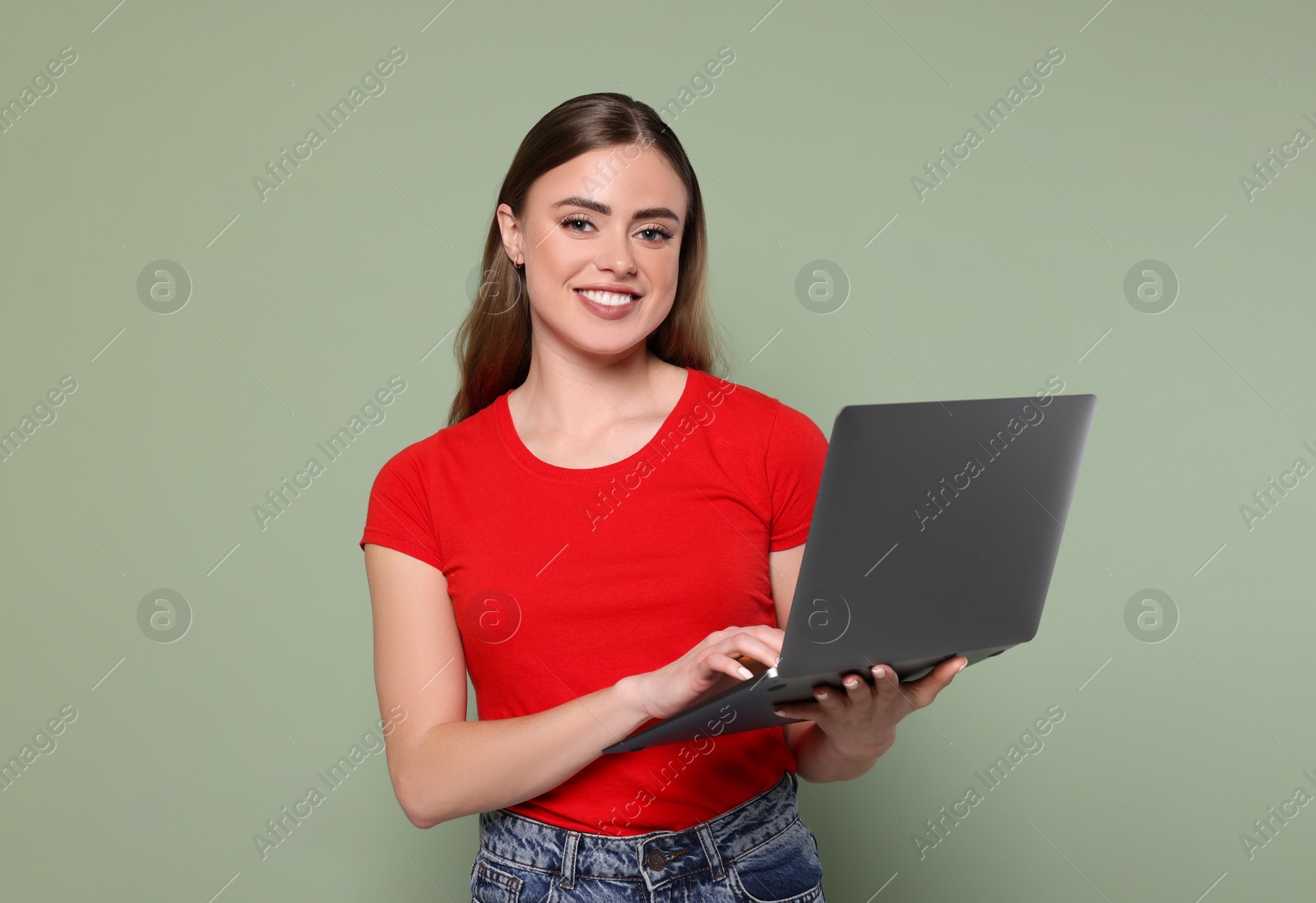 Photo of Happy woman with laptop on pale green background