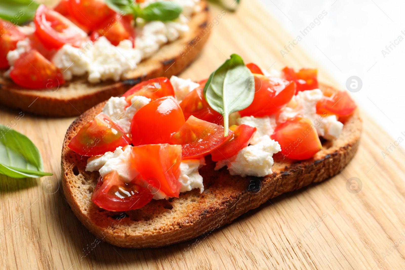 Photo of Closeup view of tasty bruschettas on wooden board