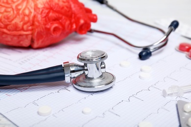 Stethoscope, cardiogram and pills on table. Cardiology service