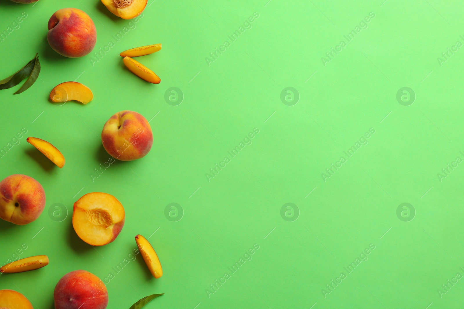 Photo of Flat lay composition with fresh peaches on green background. Space for text