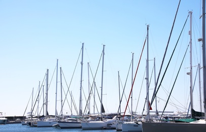 Modern boats near pier and clear blue sky