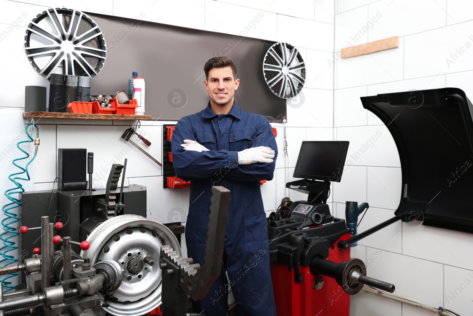 Photo of Professional worker in shop of modern tire service