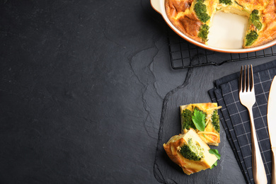 Photo of Tasty broccoli casserole served on black table, flat lay. Space for text