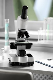 Photo of Modern medical microscope on table in laboratory