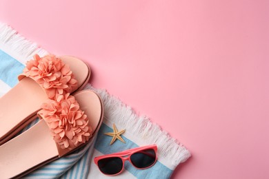 Flat lay composition with beach accessories on pink background, space for text