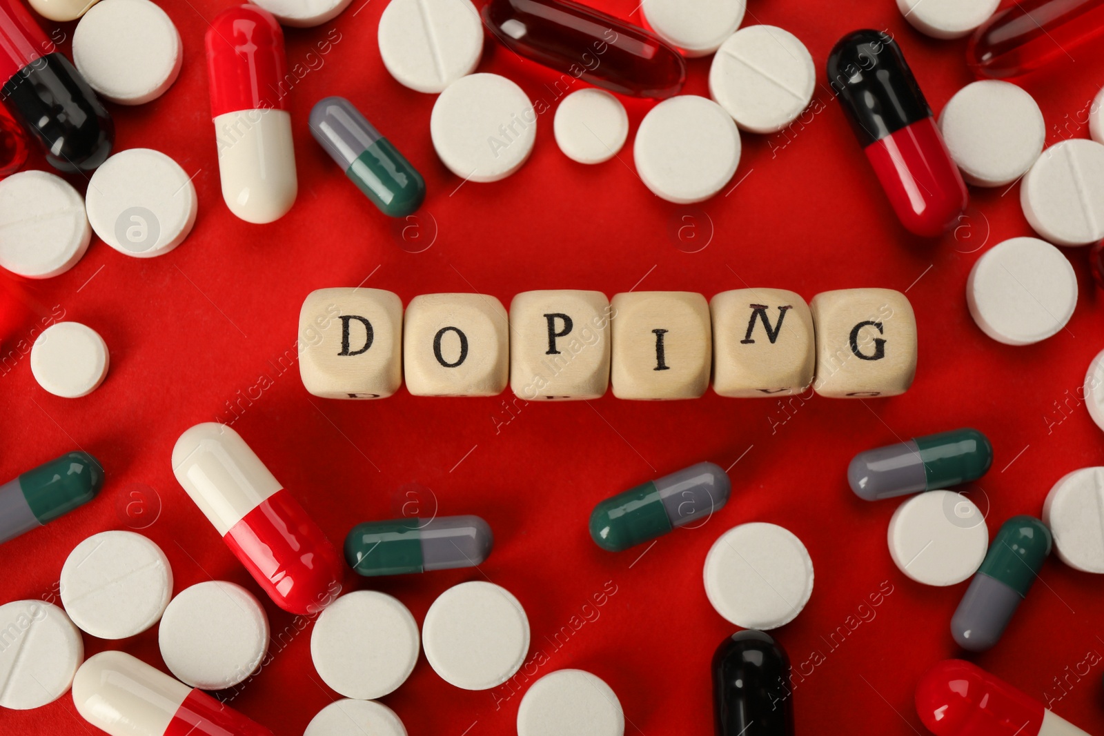Photo of Wooden cubes with word Doping and drugs on red background, flat lay