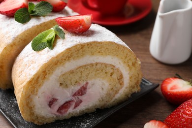 Delicious cake roll with strawberries and cream on black board, closeup