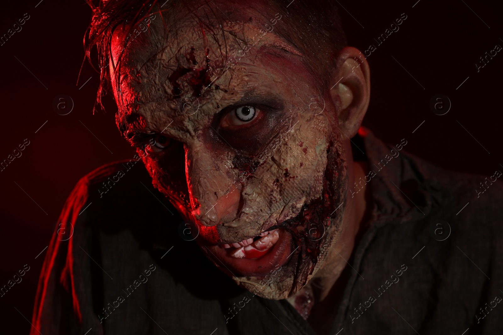 Photo of Scary zombie on dark background, closeup. Halloween monster